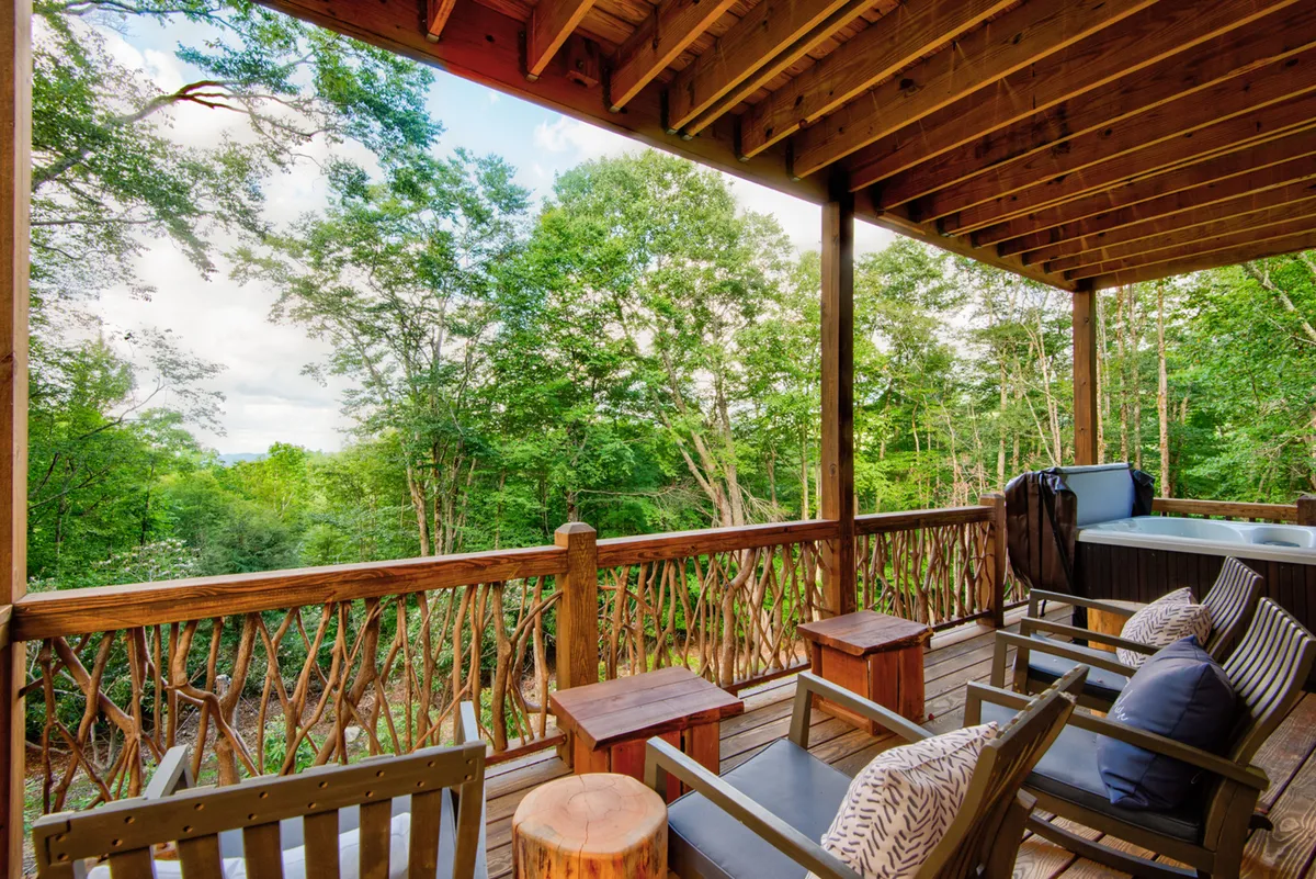A cozy outdoor hot tub set on a wooden deck, surrounded by lush greenery. The inviting setting suggests relaxation and rejuvenation, with space for socializing or enjoying a quiet soak under the stars after a day of adventure.